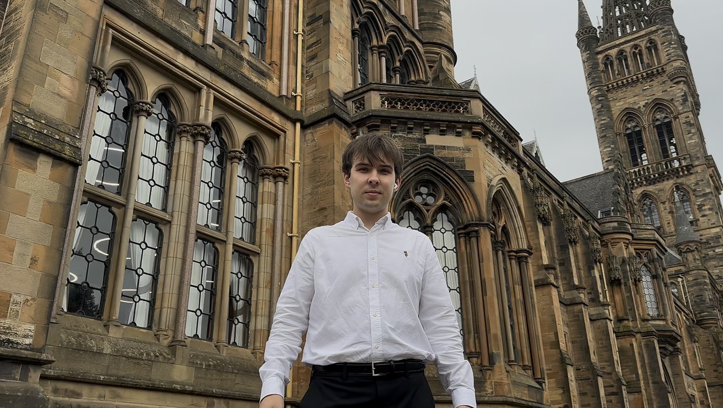 Yurii Kuzub in front of the Gilbert Scott Building of the University of Glasgow